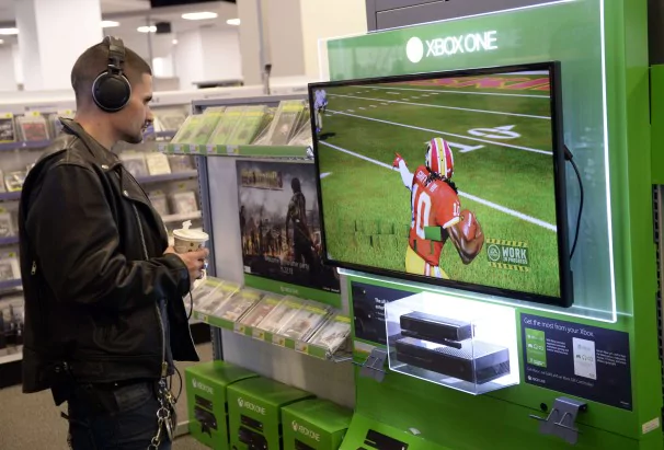 Un client regarde un écran de la console nouvelle génération de Microsoft, la Xbox Un chez Best Buy Union Square dans de New York 19 Novembre 2013.  La Xbox One sera lancé le 22 Novembre 2013. AFP PHOTO / TIMOTHY CLARYTIMOTHY CLARY / AFP / Getty Images